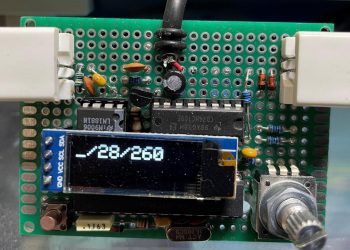 A small green circuit board with a tiny OLED display