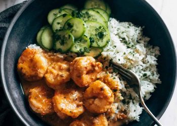 Chipotle orange shrimp in a bowl with rice and cucumbers