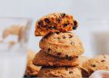Stack of vegan gluten-free pumpkin chocolate chip cookies with the top one broken apart to show the texture