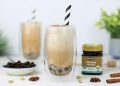Two healthy, iced chai boba teas and a jar of Flora Manuka Honey