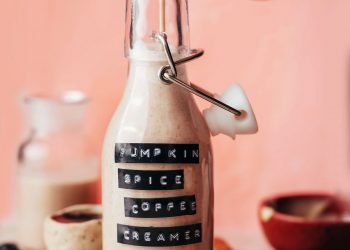 Pouring dairy-free pumpkin spice coffee creamer into a small bottle