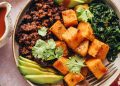 Breakfast bowl with roasted squash, avocado, sautéed spinach, seasoned black beans, and cilantro
