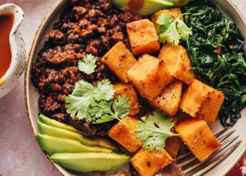 Breakfast bowl with roasted squash, avocado, sautéed spinach, seasoned black beans, and cilantro