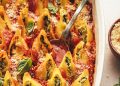 Spoon in a baking dish of vegan stuffed shells