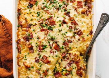 Corn casserole in a casserole dish with a serving spoon.